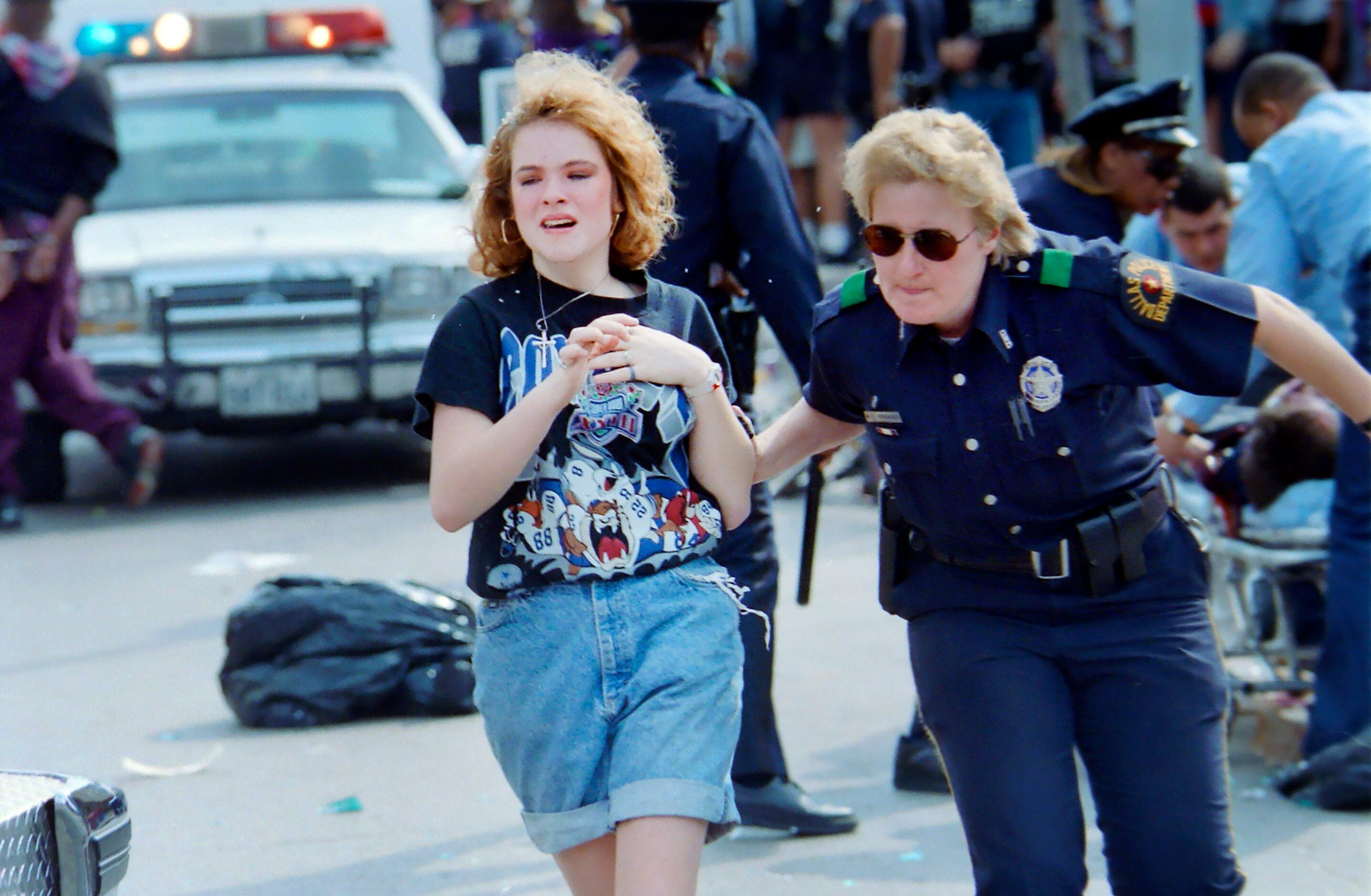 A Dallas Police officer moves a teenager away from violence that erupted along Commerce St...