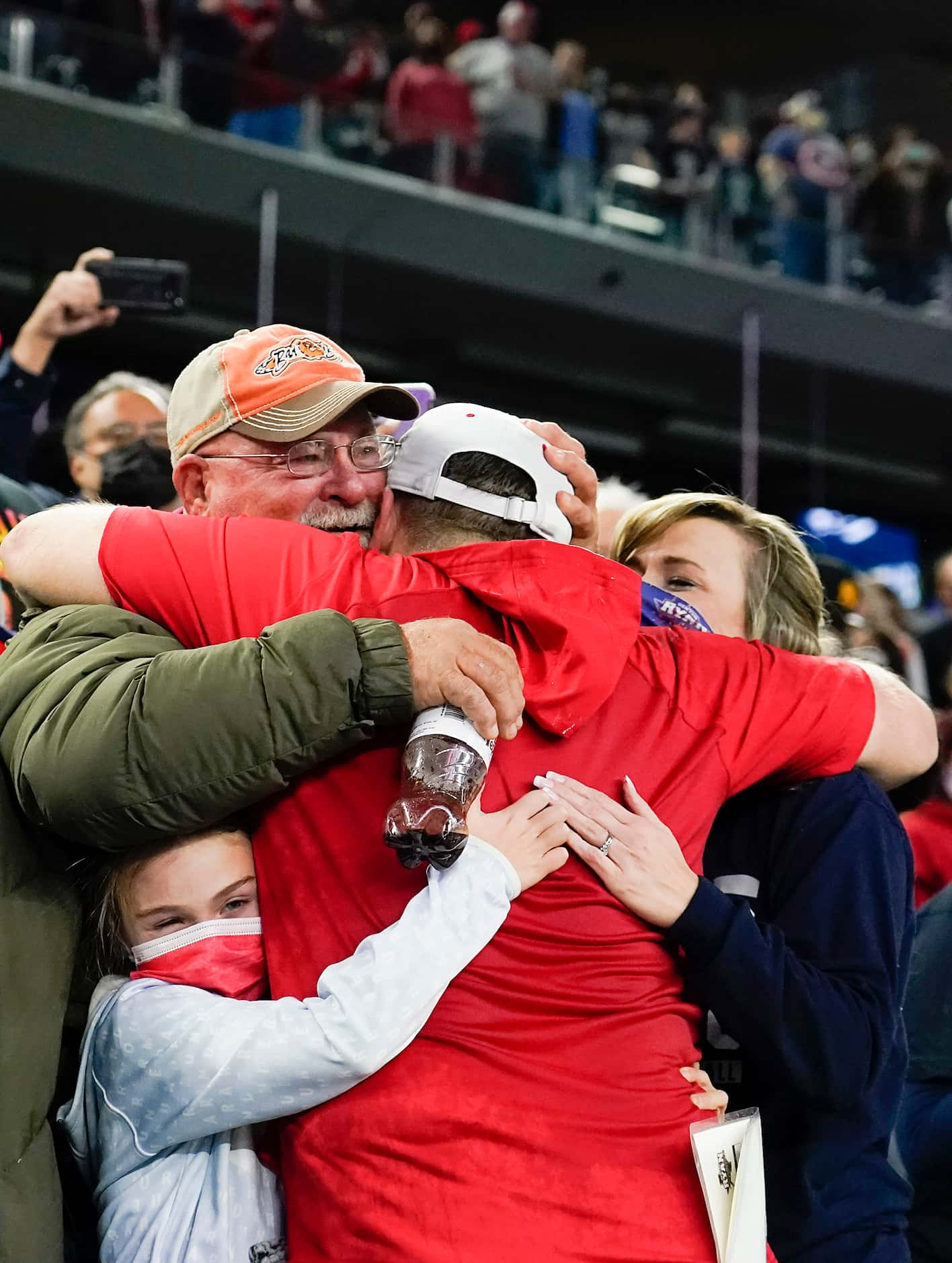 Denton Ryan assistant coach Shane Tolleson gets a hug from family in celebration of a 59-14...