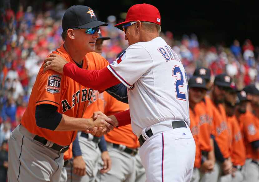 Texas Rangers manager Jeff Banister (28) shakes hands with Houston Astros manager A.J. Hinch...