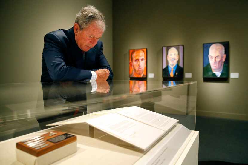 Former President George W. Bush reads one of the veteran letters on display of 'Portraits of...