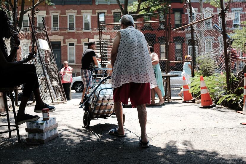 A woman walks away from a free food pantry in the Bronx, one of the poorest congressional...