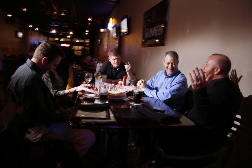 A group from  Pioneer Natural Resources enjoys food and drinks during happy hour at the...
