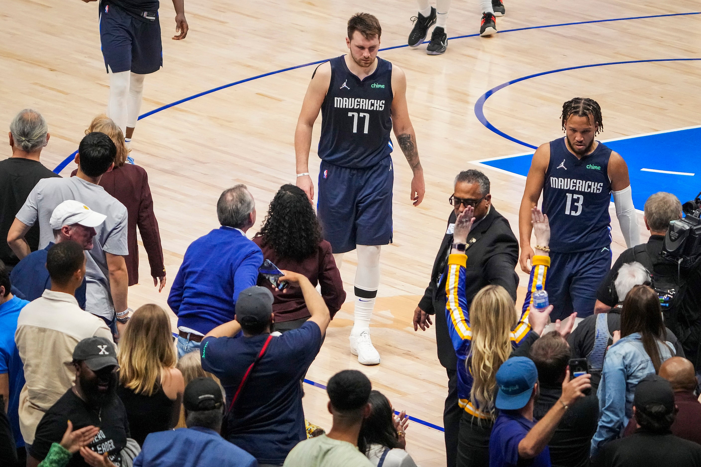 Dallas Mavericks guard Luka Doncic (77) and guard Jalen Brunson (13) leave the court...