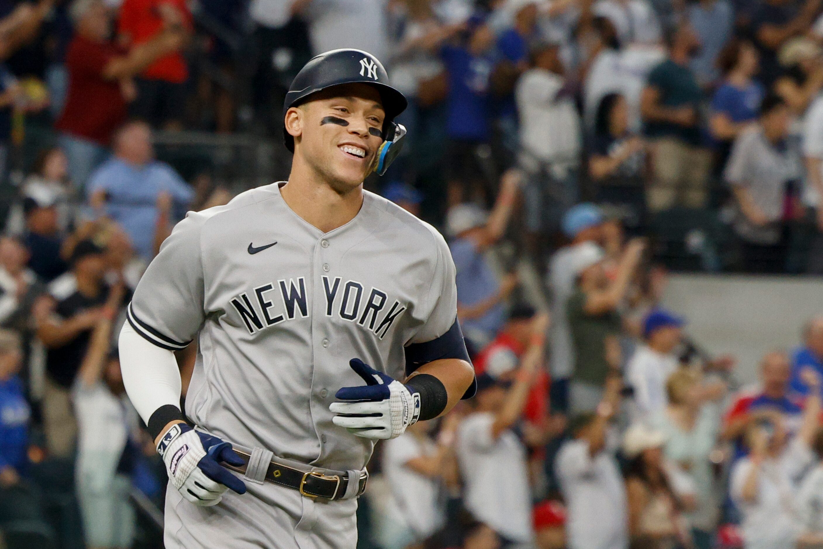 New York Yankees right fielder Aaron Judge (99) smiles after hitting a home run to left...