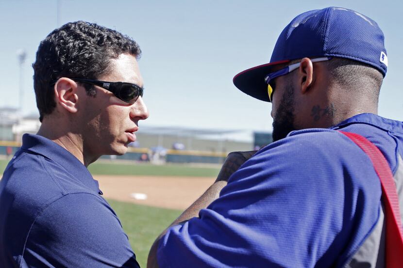 Texas general manager Jon Daniels. left, talks with first baseman Prince Fielder before the...