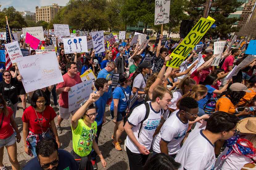 Demonstrators march to Dallas City Hall during a rally in support of gun safety laws on...