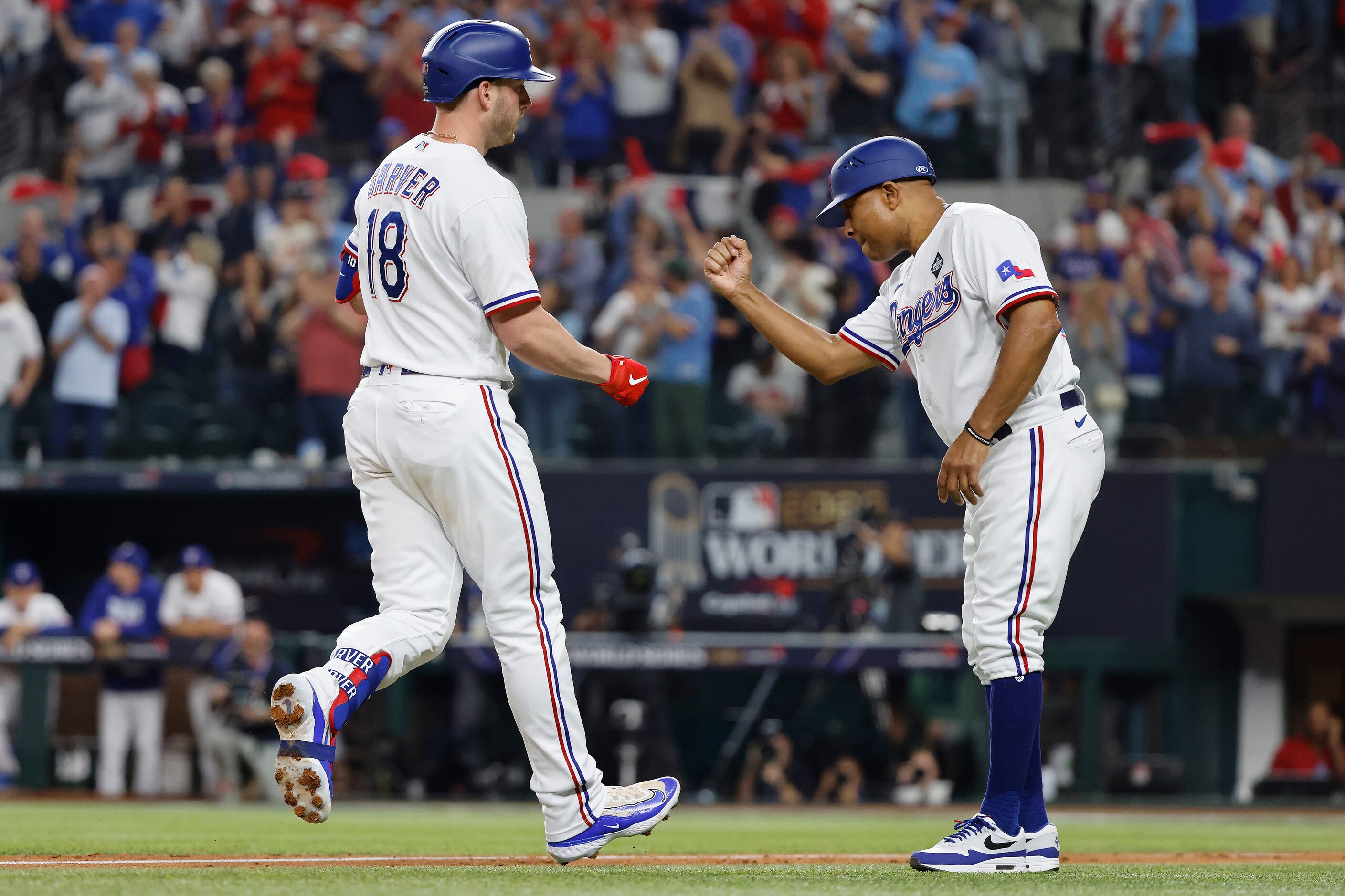 Texas Rangers designated hitter Mitch Garver is congratulated by third base coach Tony...