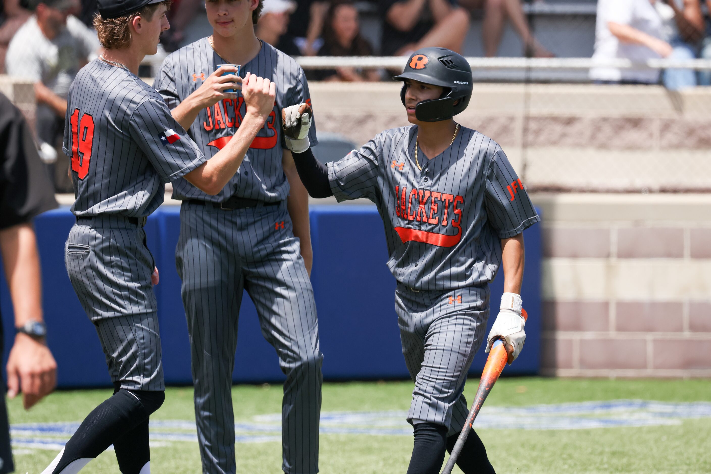 Rockwall junior pitcher Casey Giese (19) fist bumps senior outfielder Drew Estrada (right)...