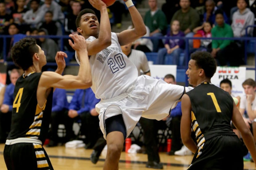 Plano West Wolves guard Chris Giles (20) puts up a shot against Plano East Panthers guard...