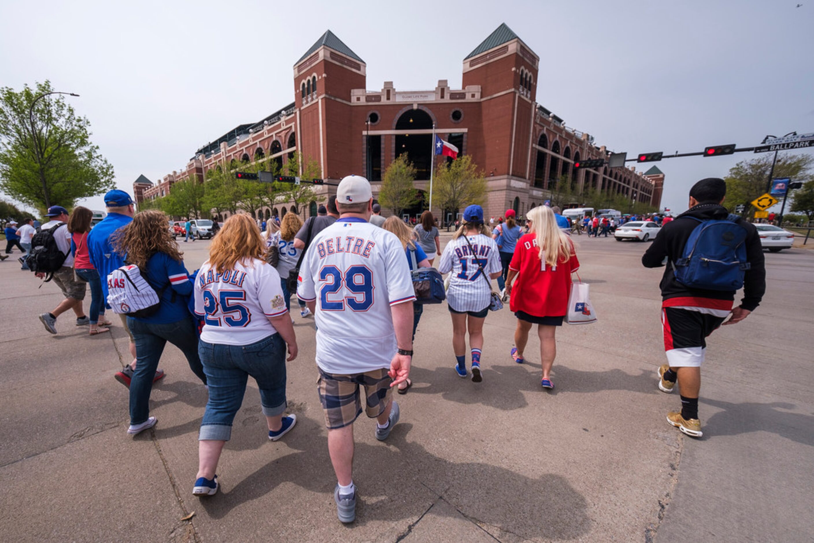 Fans head for the stadium for the Texas Rangers opening day game against the Chicago Cubs at...