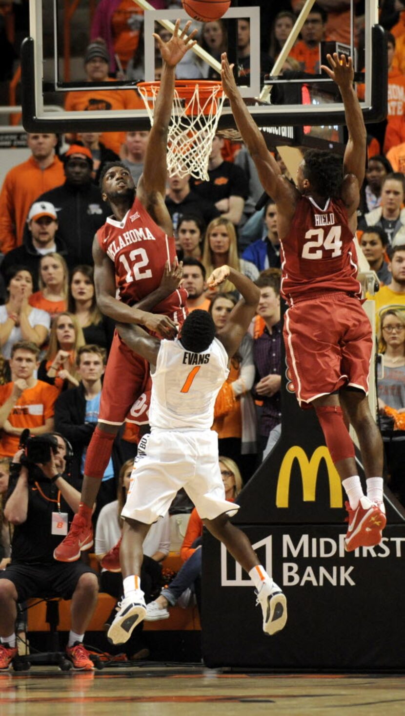 Oklahoma forward Khadeem Lattin (12) and guard Buddy Hield (24) defend against a shot by...