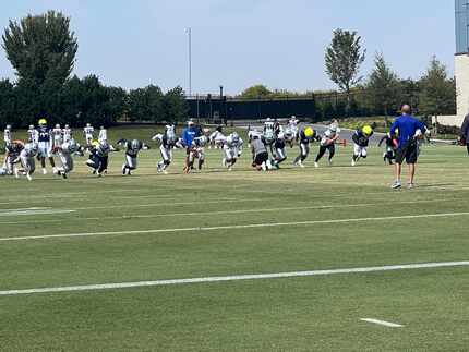 Cowboys players participate in a drill concentrated on getting off the snap during an...