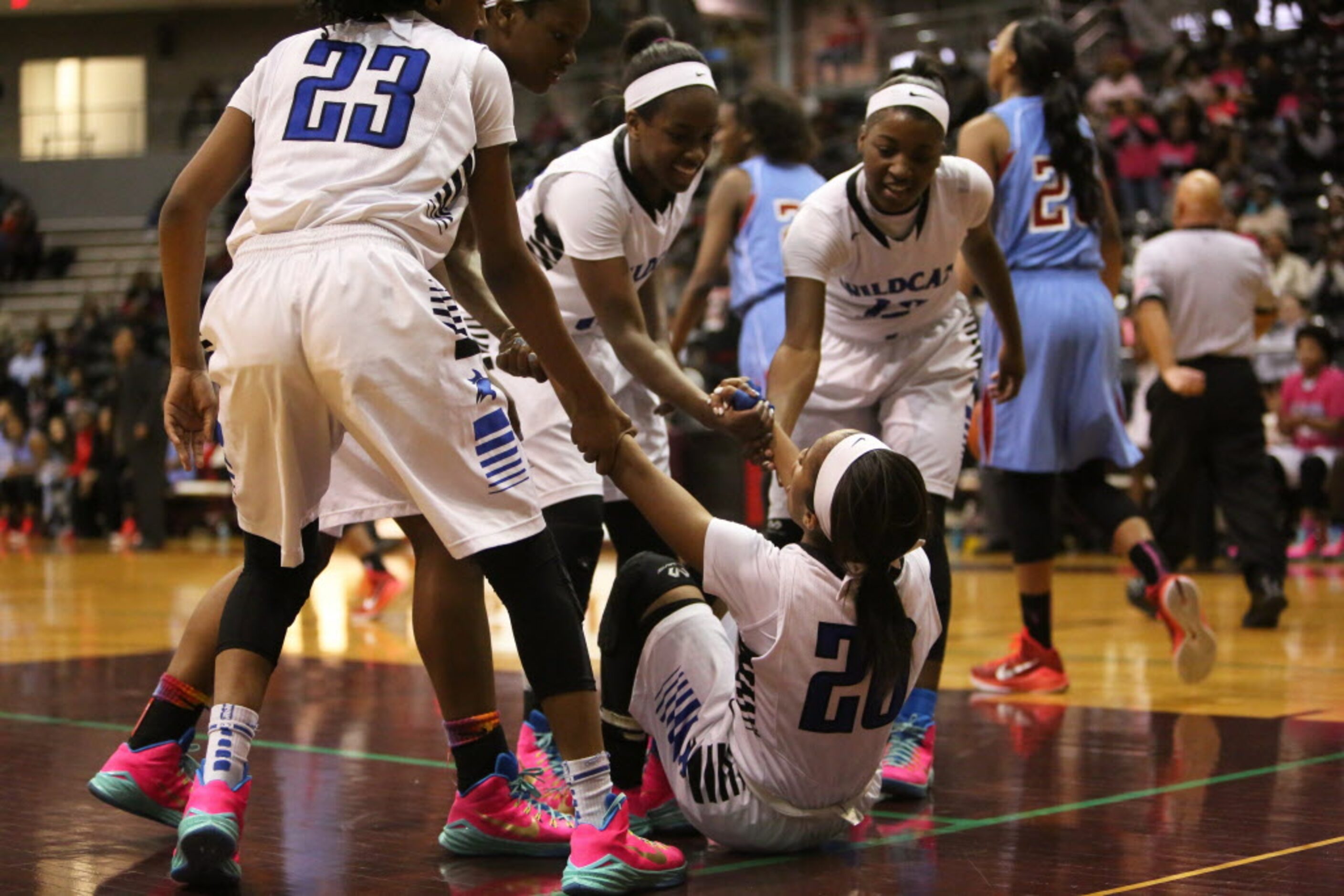 Dekaney point guard Jaelyn Richard-Harris (20) is picked up by teammates during the second...