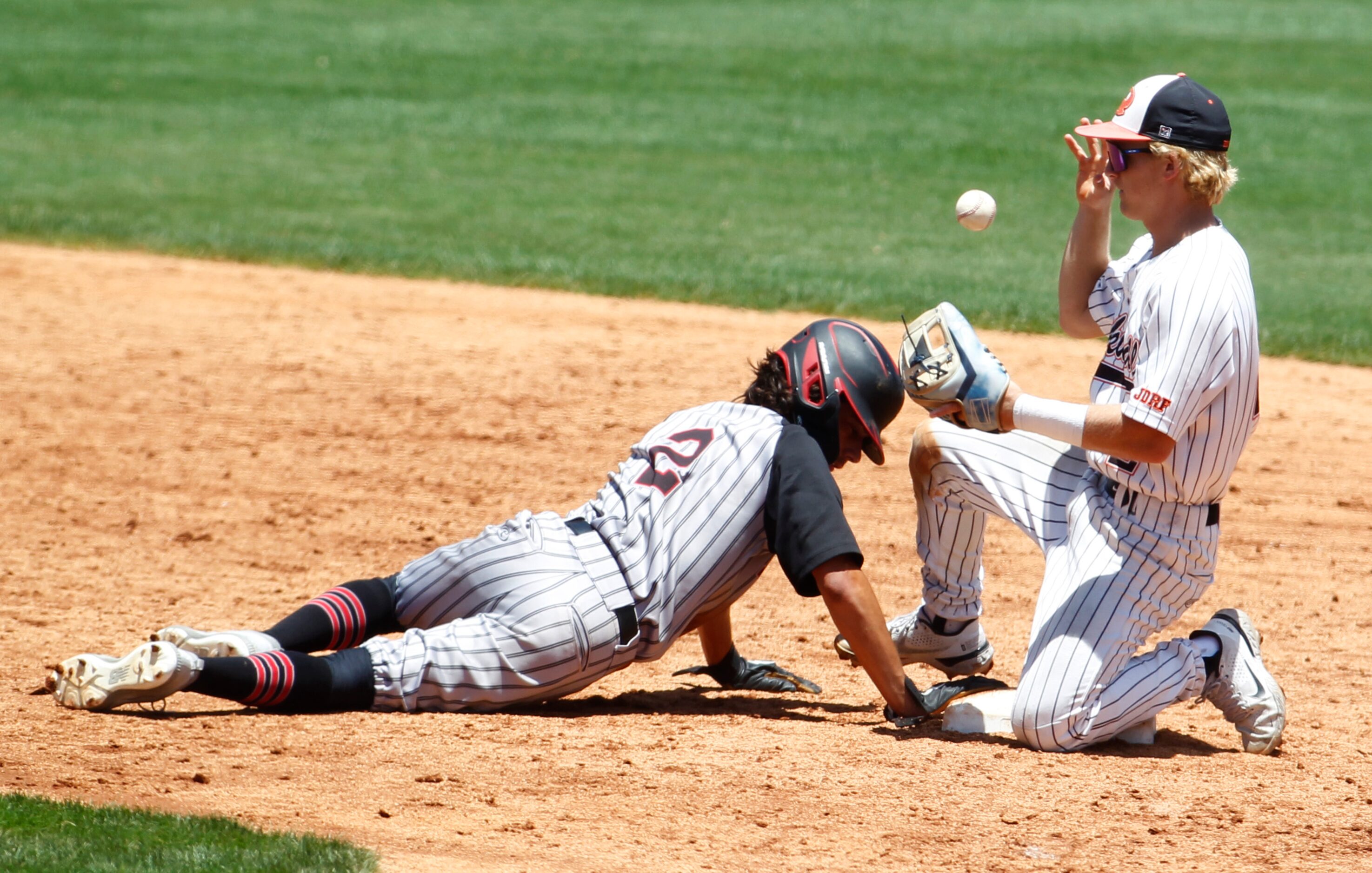 Rockwall Heath baserunner Alex Stowers (2) slides safely back into second base to avoid a...