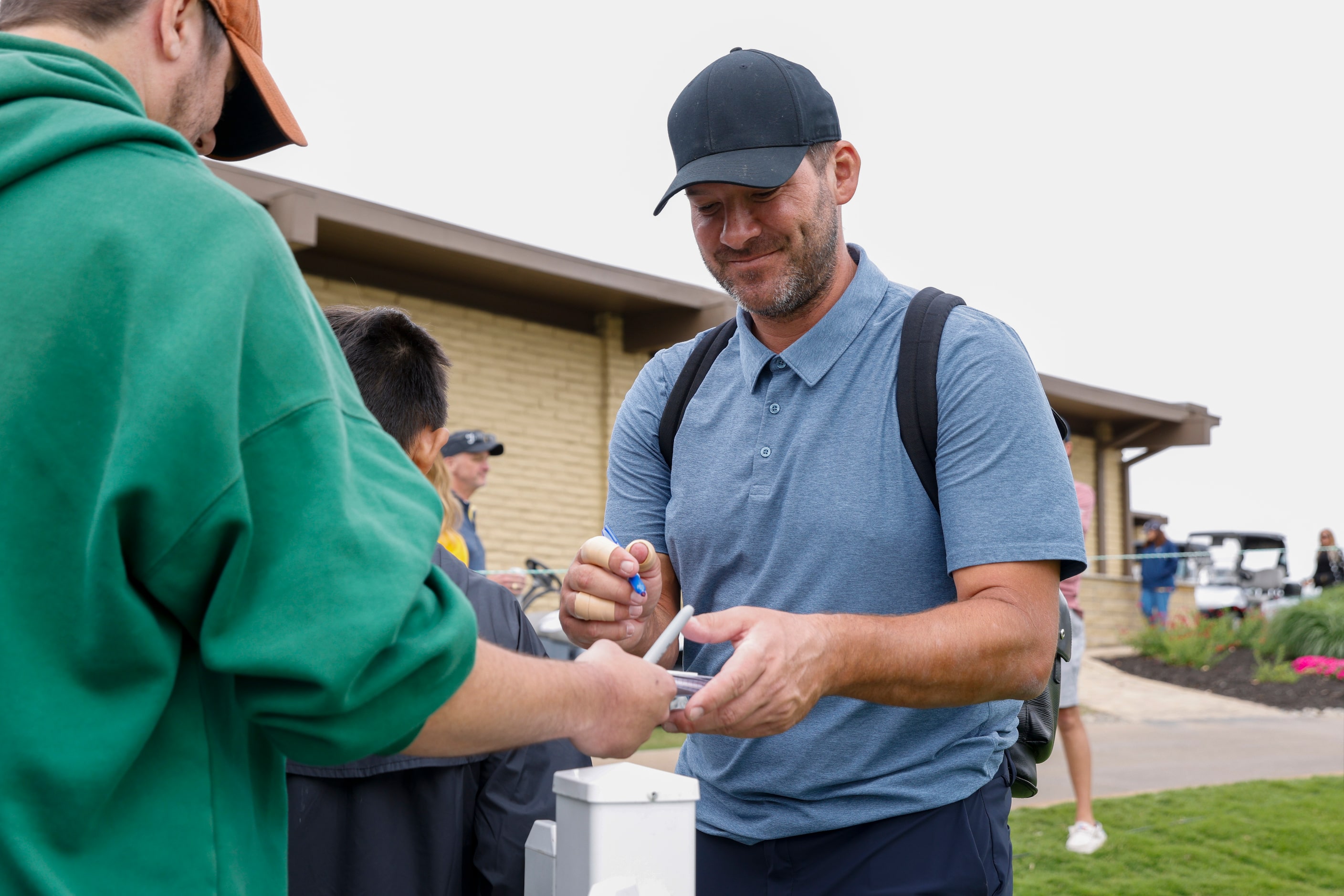 Former Dallas Cowboys quarterback Tony Romo signs autographs for fans after the first round...