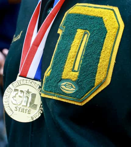 A DeSoto High School football player wears his state championship medal during Saturday's...