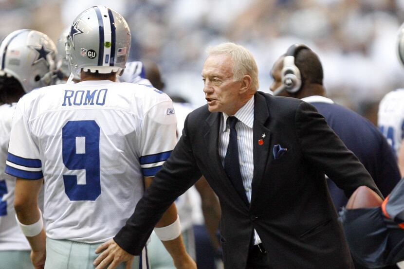 Dallas Cowboys' owner Jerry Jones taps quarterback Tony Romo (9) after coming off the field...