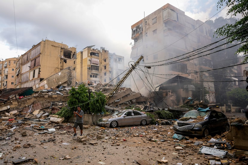 A man checks the damaged buildings at the site of an Israeli airstrike in Beirut's southern...