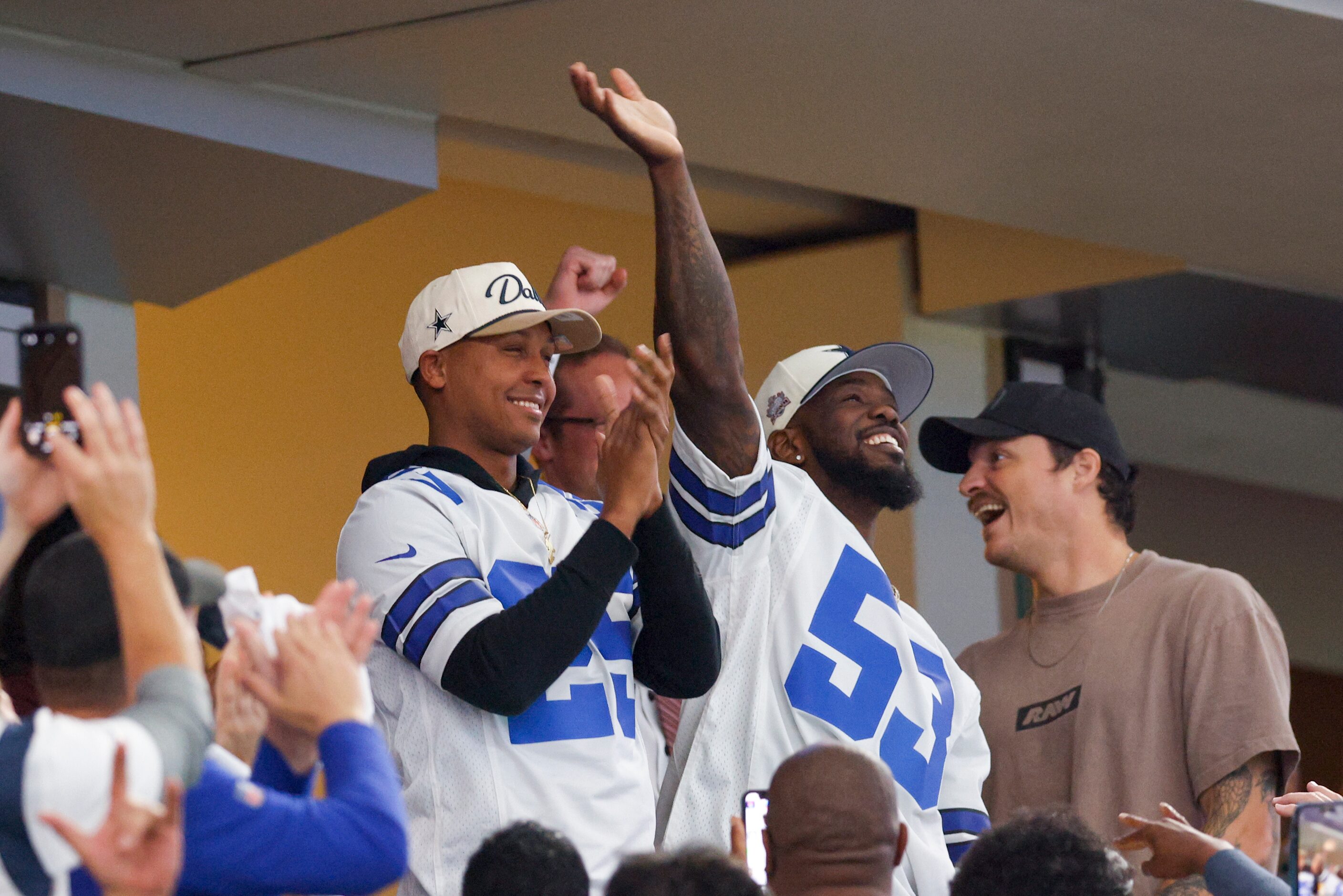 Texas Rangers pitcher Jose Leclerc (left) and outfielder Adolis Garcia wave to the crowd as...