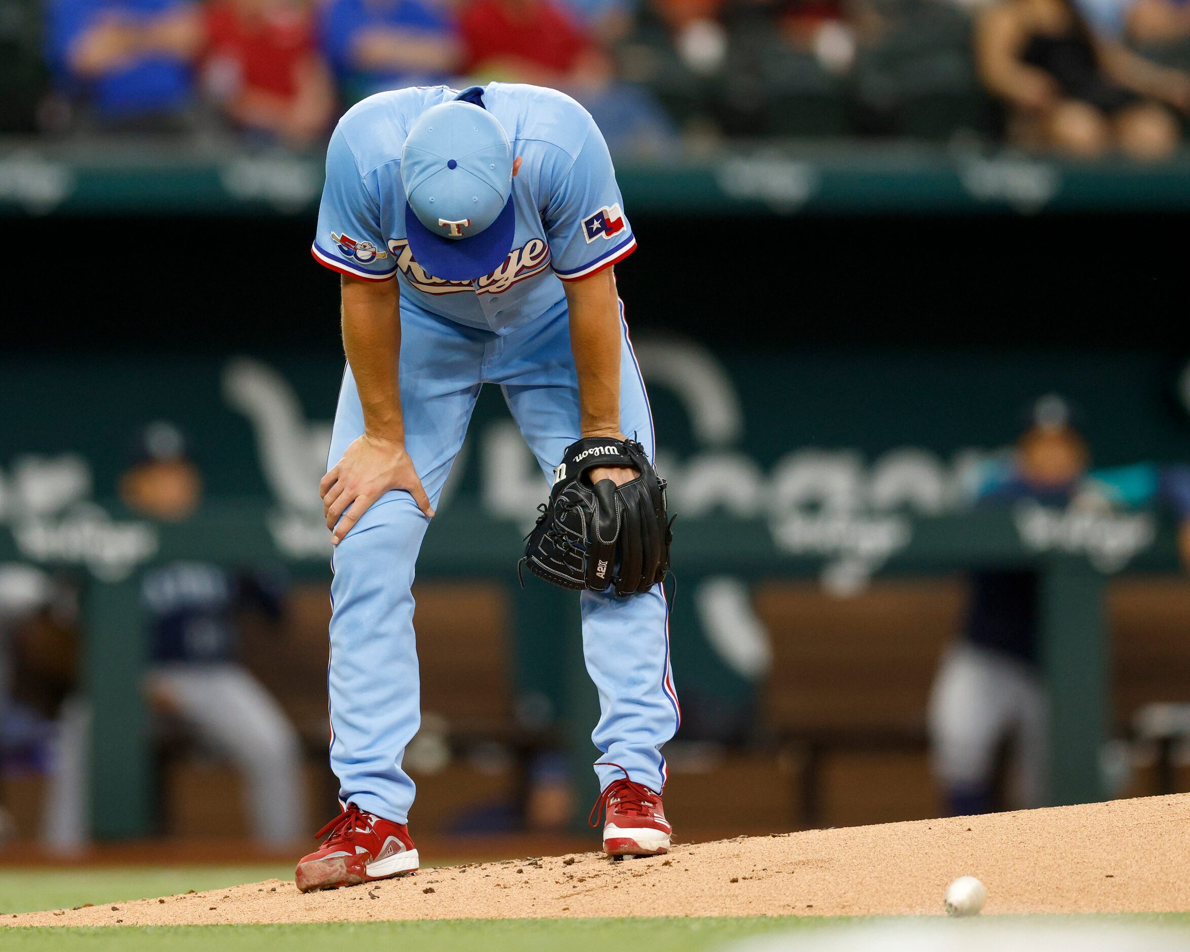 Texas Rangers starting pitcher Glenn Otto (49) reacts after being hit by a broken bat during...