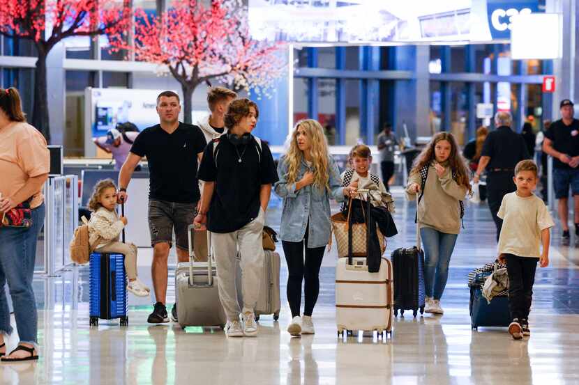Travelers make their way around Terminal C at DFW International Airport, Tuesday, Aug. 22,...
