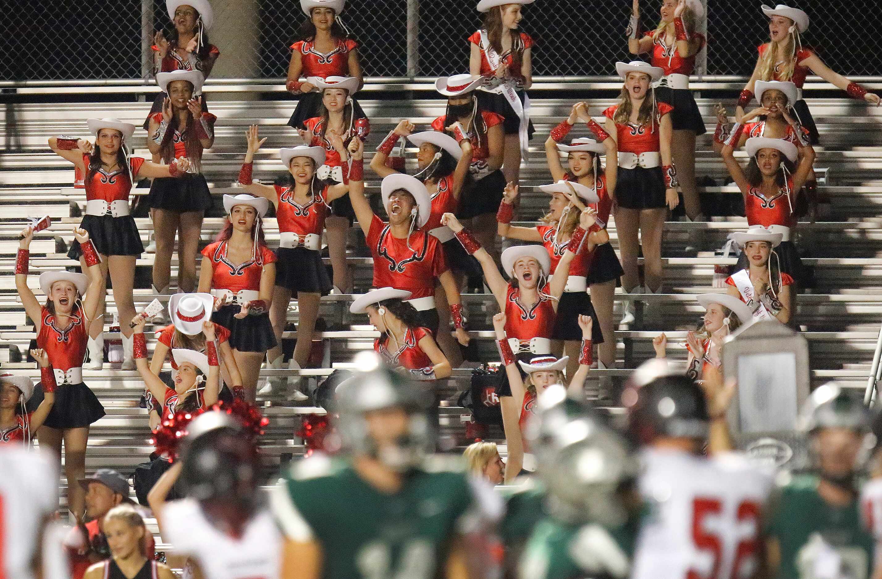 The Liberty High School Red Rythm drill team cheers as their football team tied the score...
