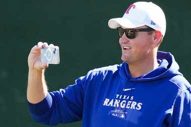 Texas Rangers executive vice president & general manager Chris Young trains his camera as...
