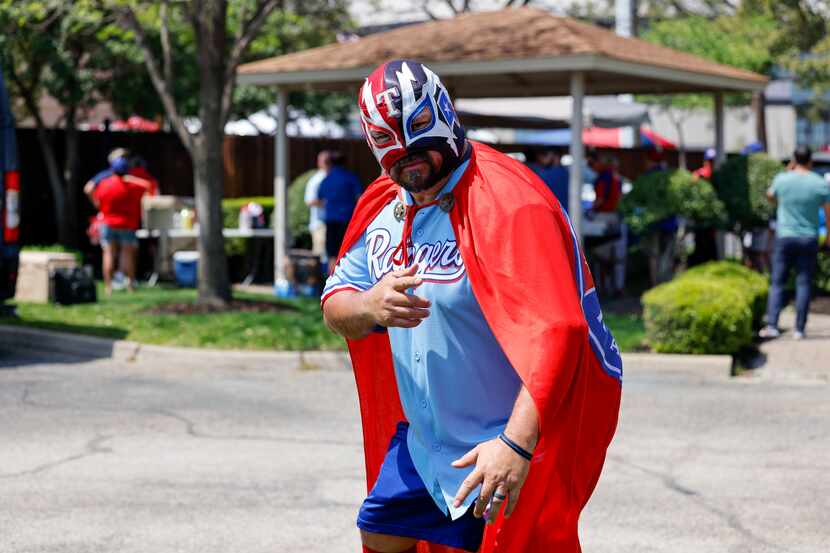 David “El Nacho Ranger” Lara shows off his cape and mask before the Texas Rangers home...