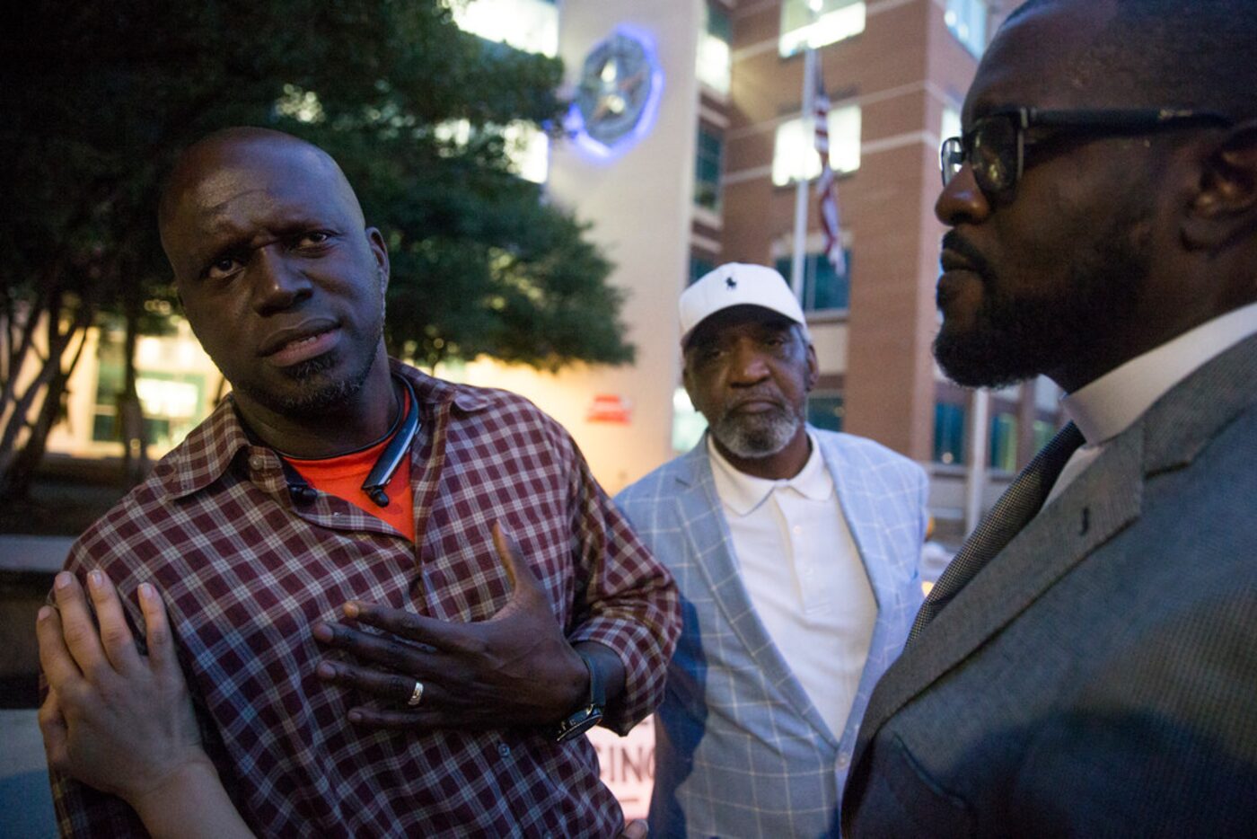 Jean family friend Dane Felicien (left) talks to pastors Robert Conley and Michael W. Waters...