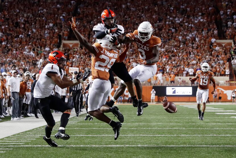 Texas defensive back Josh Thompson (29) and defensive back Jalen Green (3) break up a pass...