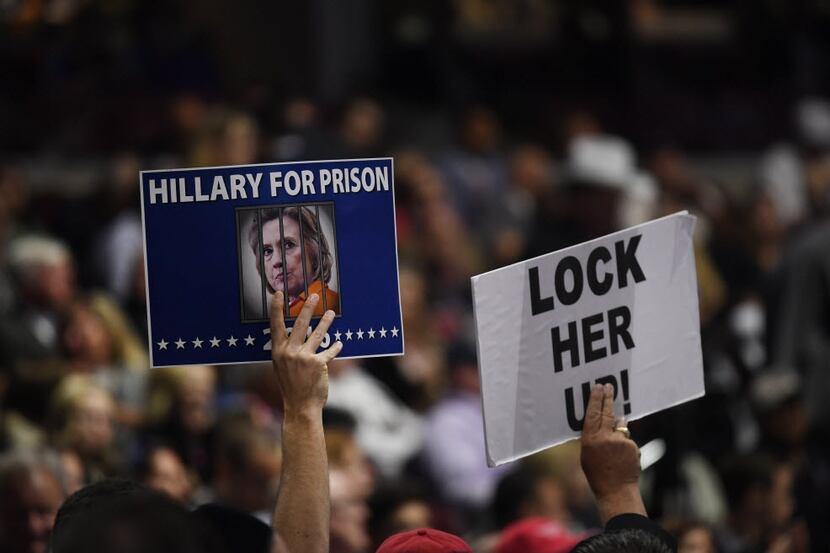 Republican delegates hold signs reading "Hillary For Prison" and "Lock Her Up!" at last...