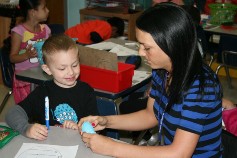Kindergartener Phoenix Wood works with his teacher Amanda Cason on a spelling exercise at...