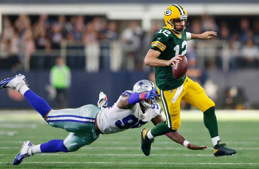 Green Bay Packers quarterback Aaron Rodgers escapes the grasp of Dallas Cowboys defensive...