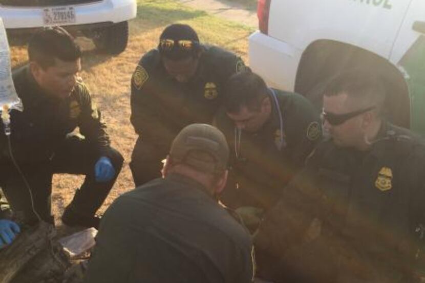 Border Patrol agents work to stabilize a woman found unresponsive and suffering from...