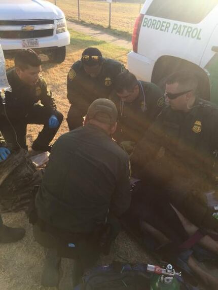 Border Patrol agents work to stabilize a woman found unresponsive and suffering from...
