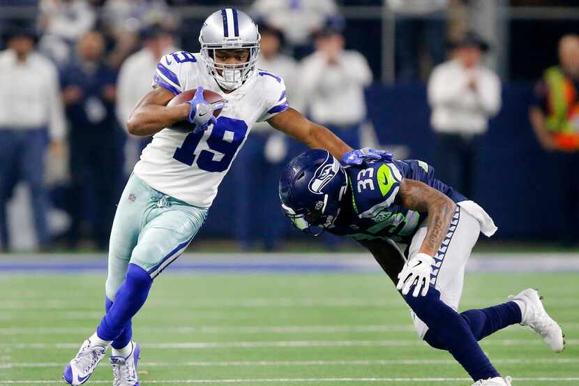 Cowboys wide receiver Amari Cooper (19) tries to avoid a tackle by Seattle Seahawks free...