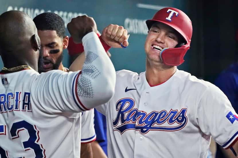 Texas Rangers' Josh Jung, right, celebrates his solo home run against the Detroit Tigers...