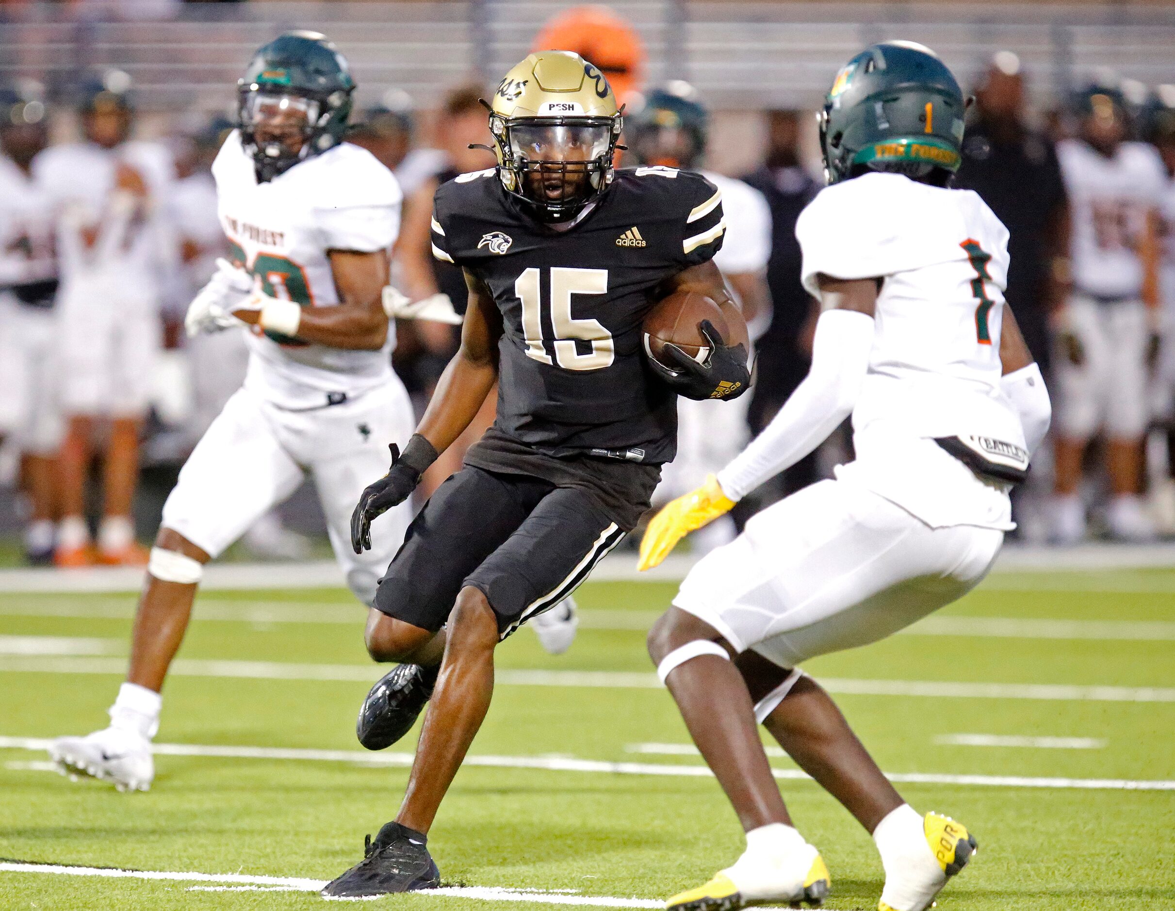 Plano East Senior High School wide receiver Elijah Prince (15) tries to get past Naaman...