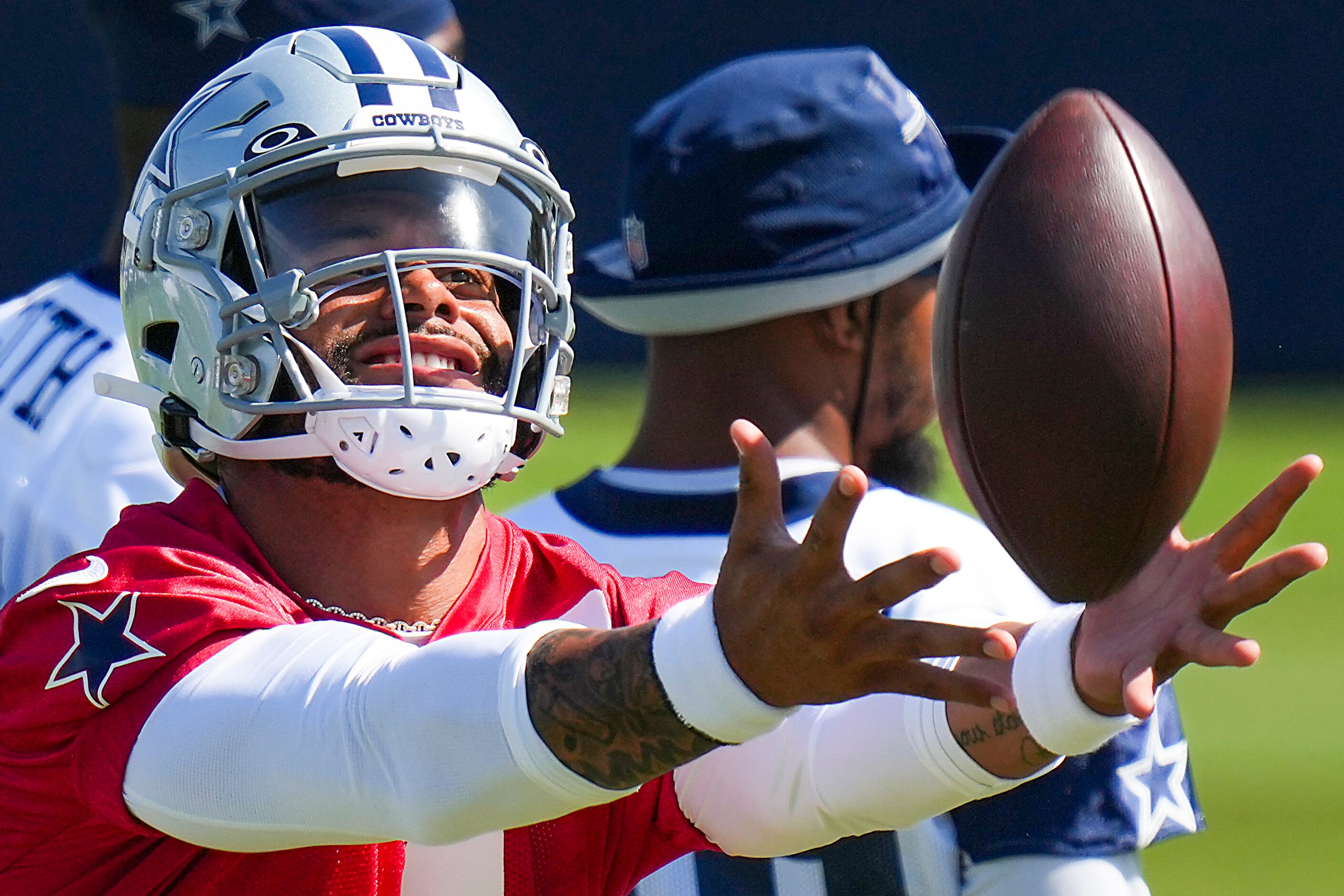 Dallas Cowboys quarterback Dak Prescott catches a football during a training camp practice...