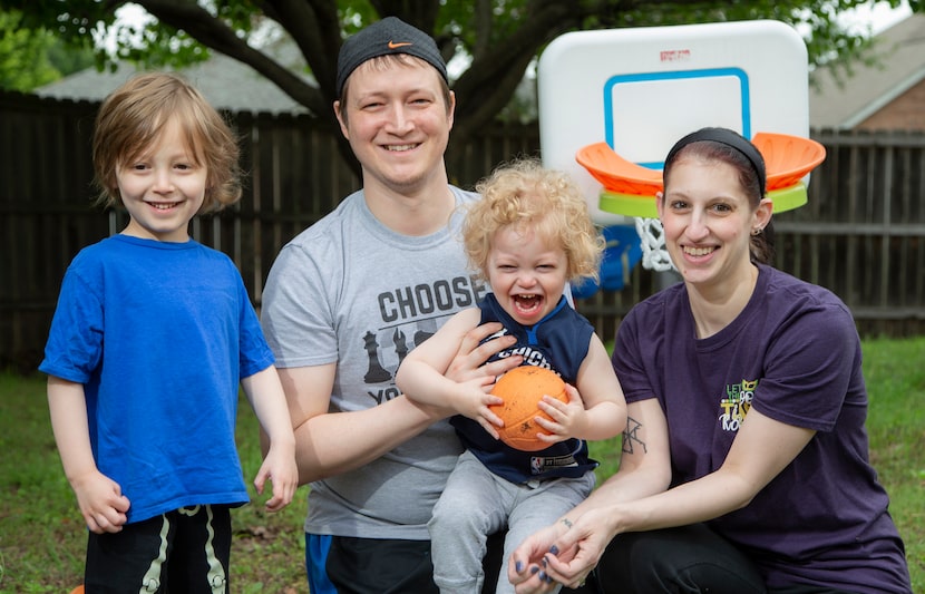 Adam and Grace Miller pose for a photo with their sons, Liam, 4, left, and Luka, 2, named...