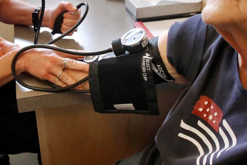 Un asistente médico toma la presión arterial a un paciente. Parkland Health ofrece atención...