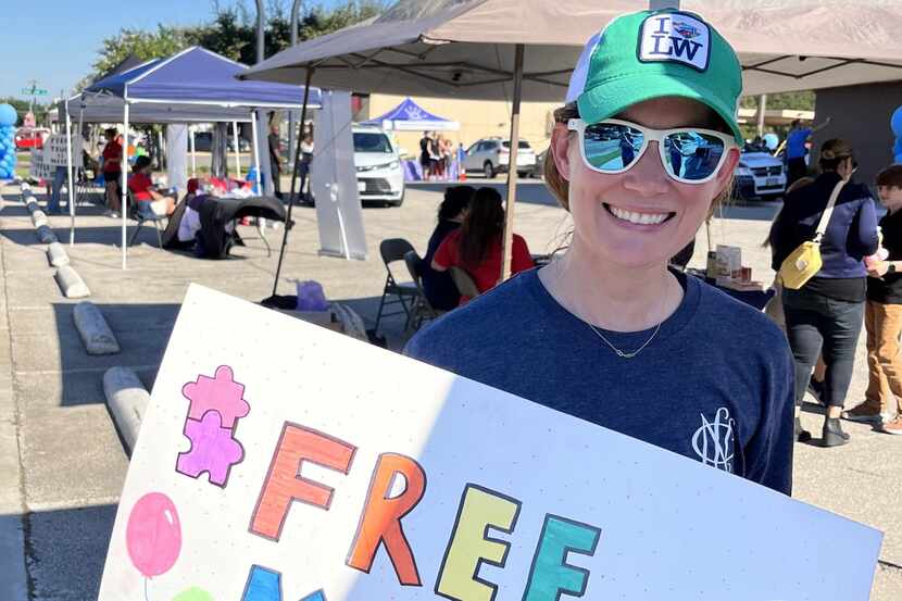 Woman carries sign at event for Annie's Place