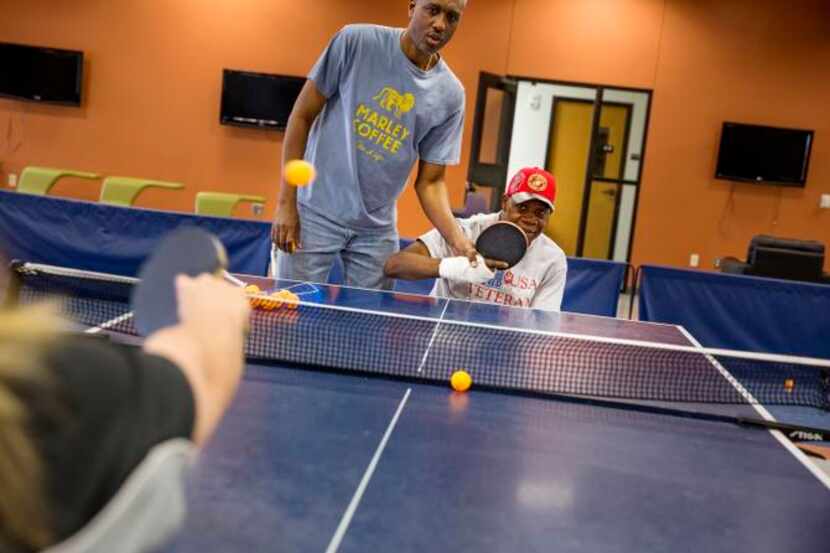 
Paralympic table tennis coach Keith Evans helps Quintin Stephens with his backhand stroke...