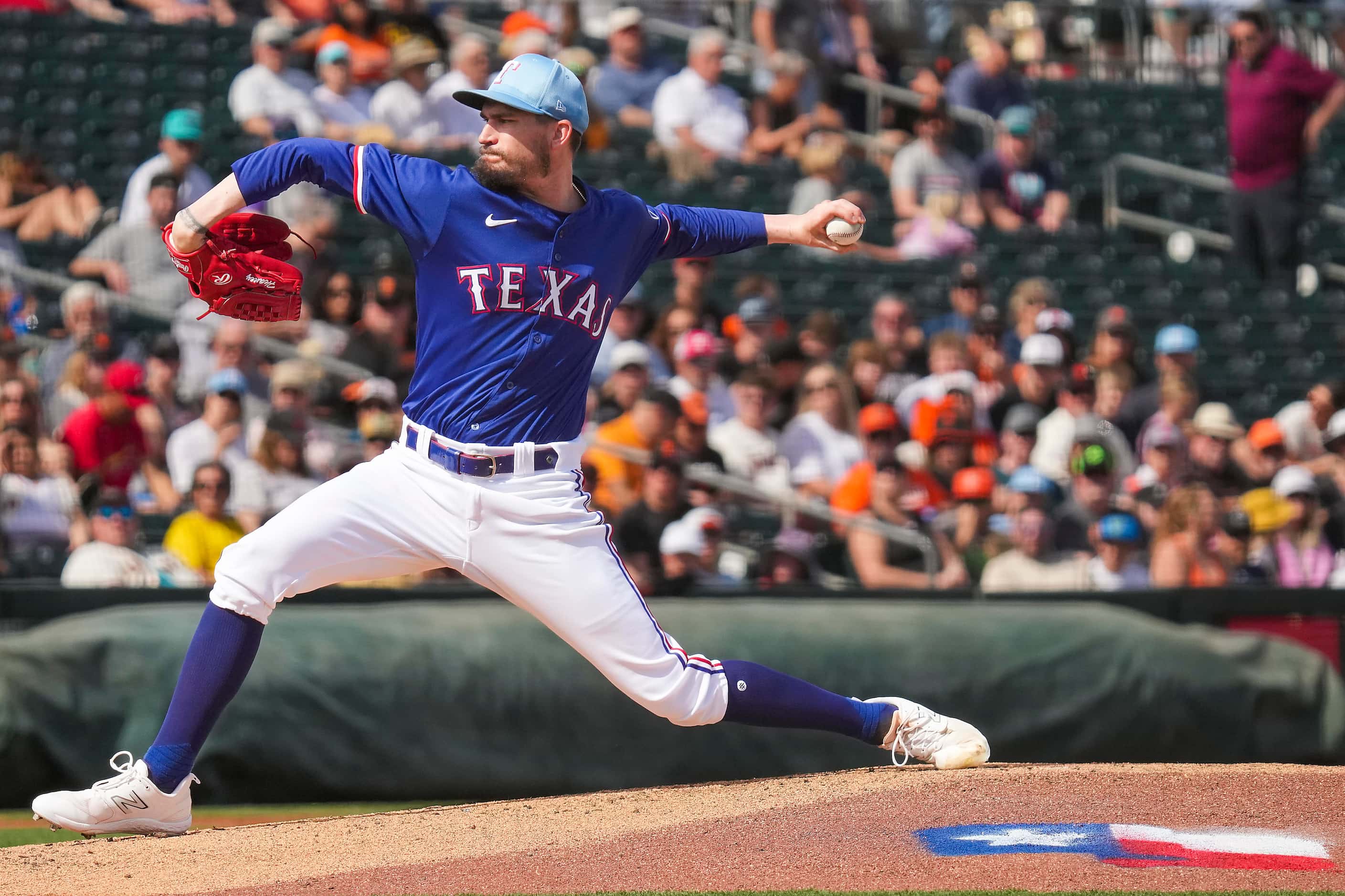 Texas Rangers pitcher Andrew Heaney delivers during the first inning of a spring training...