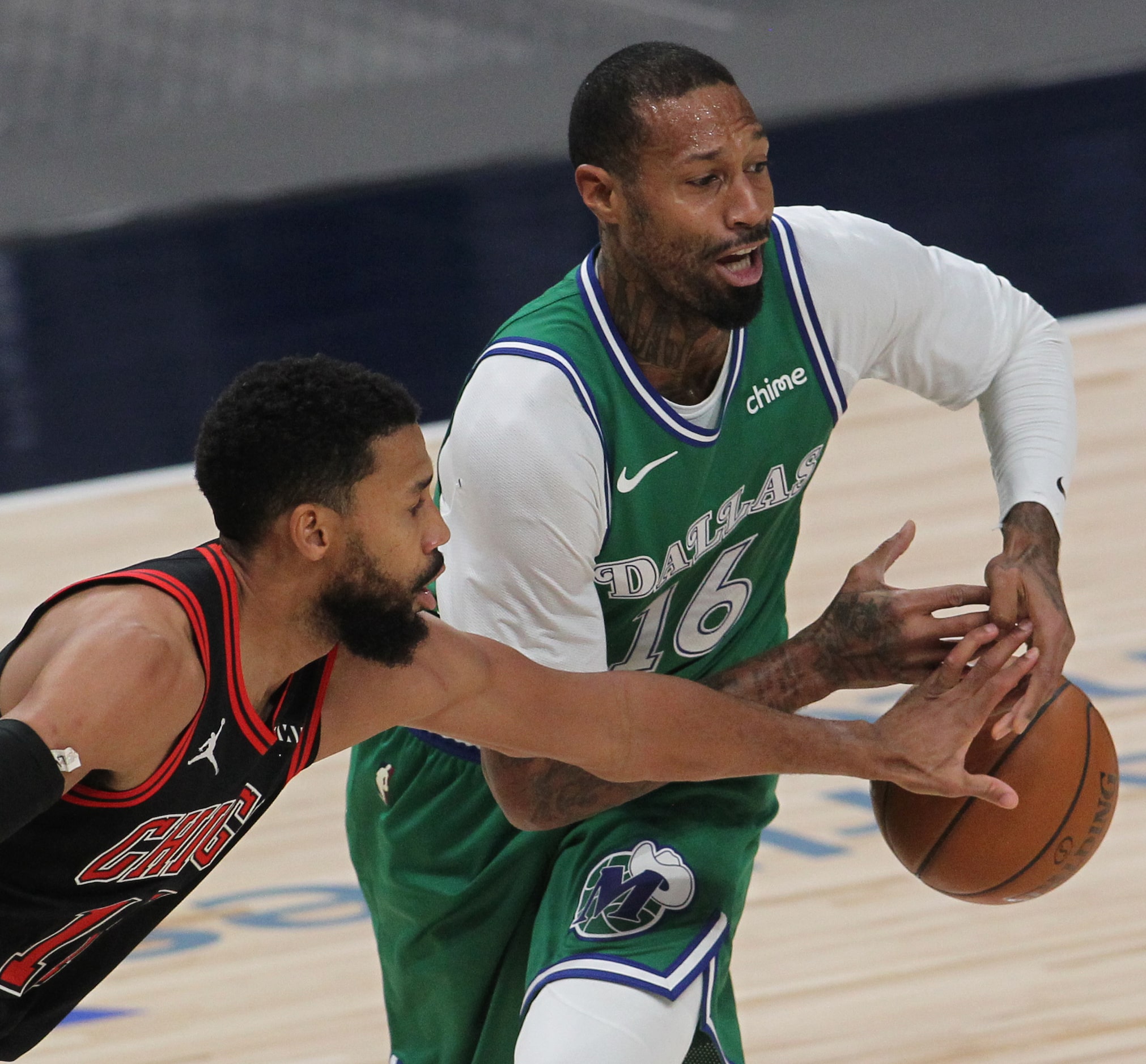 Chicago Bulls guard Garrett Temple (17), left, lunges to challenge Dallas Mavericks Forward...