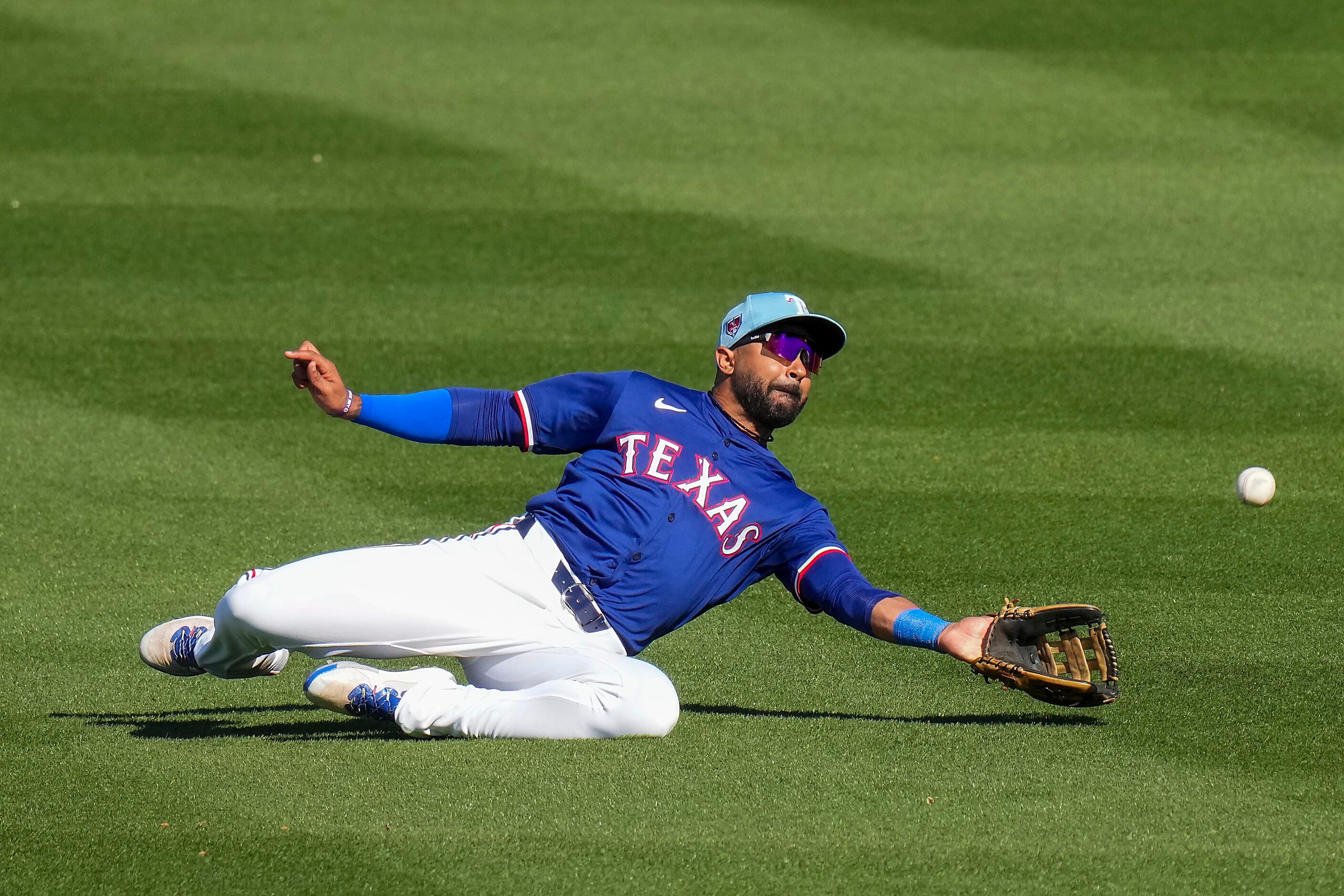 Texas Rangers outfielder Derek Hill can’t make a diving catch on a single by the Kansas City...