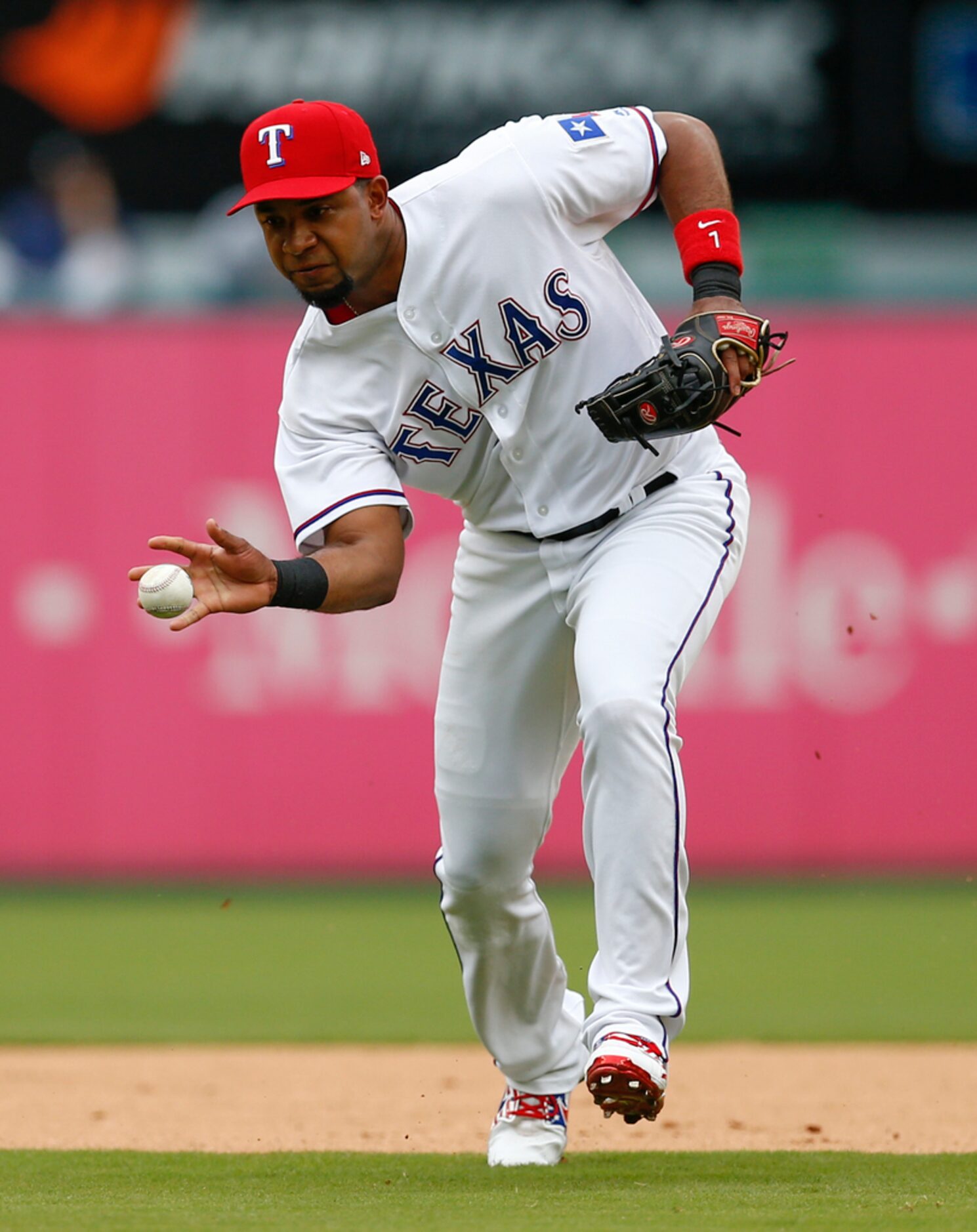 Texas Rangers shortstop Elvis Andrus barehands the ball on a ground-out hit by Seattle...