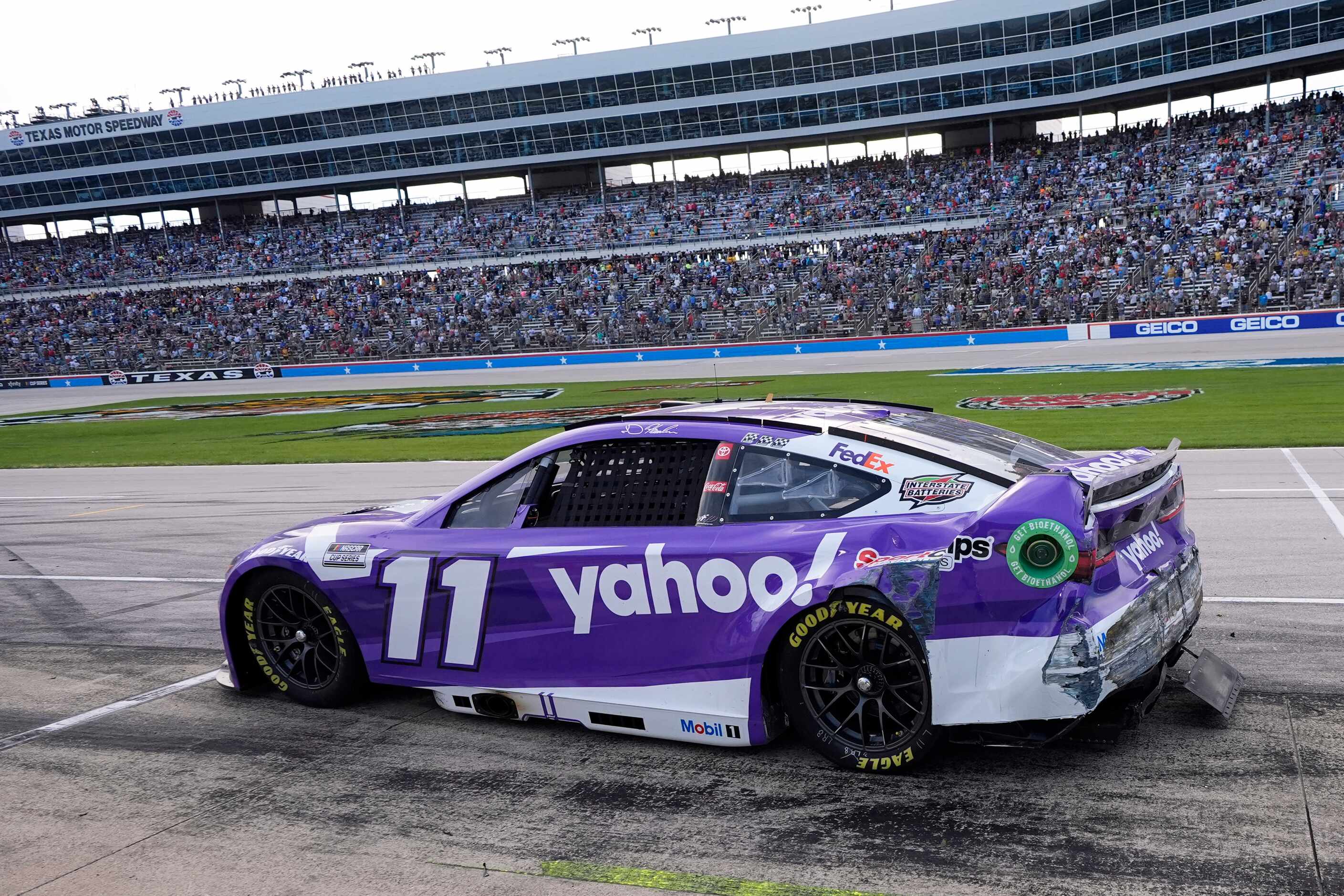 Damage to the car of Denny Hamlin is seen as he leaves pit road late in a NASCAR Cup Series...