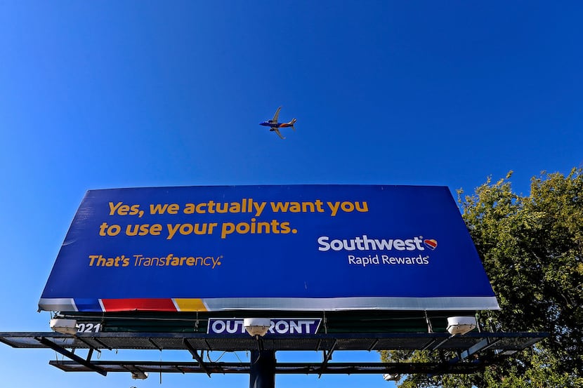 A Southwest Airlines jet flies over a billboard on Mockingbird Lane near the Dallas Love...