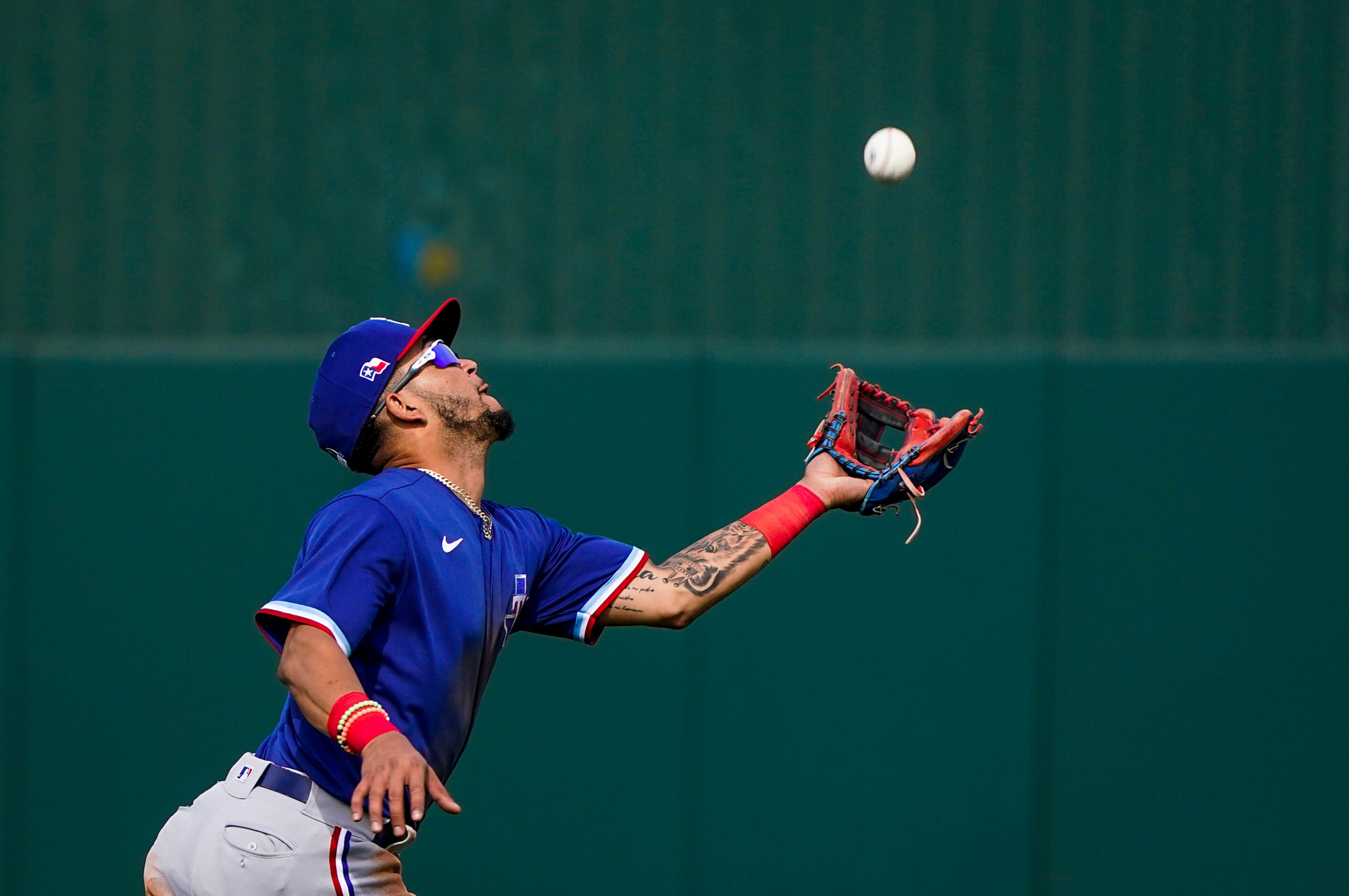 Texas Rangers infielder Anderson Tejeda races back to grab a popup off the bat of Los...